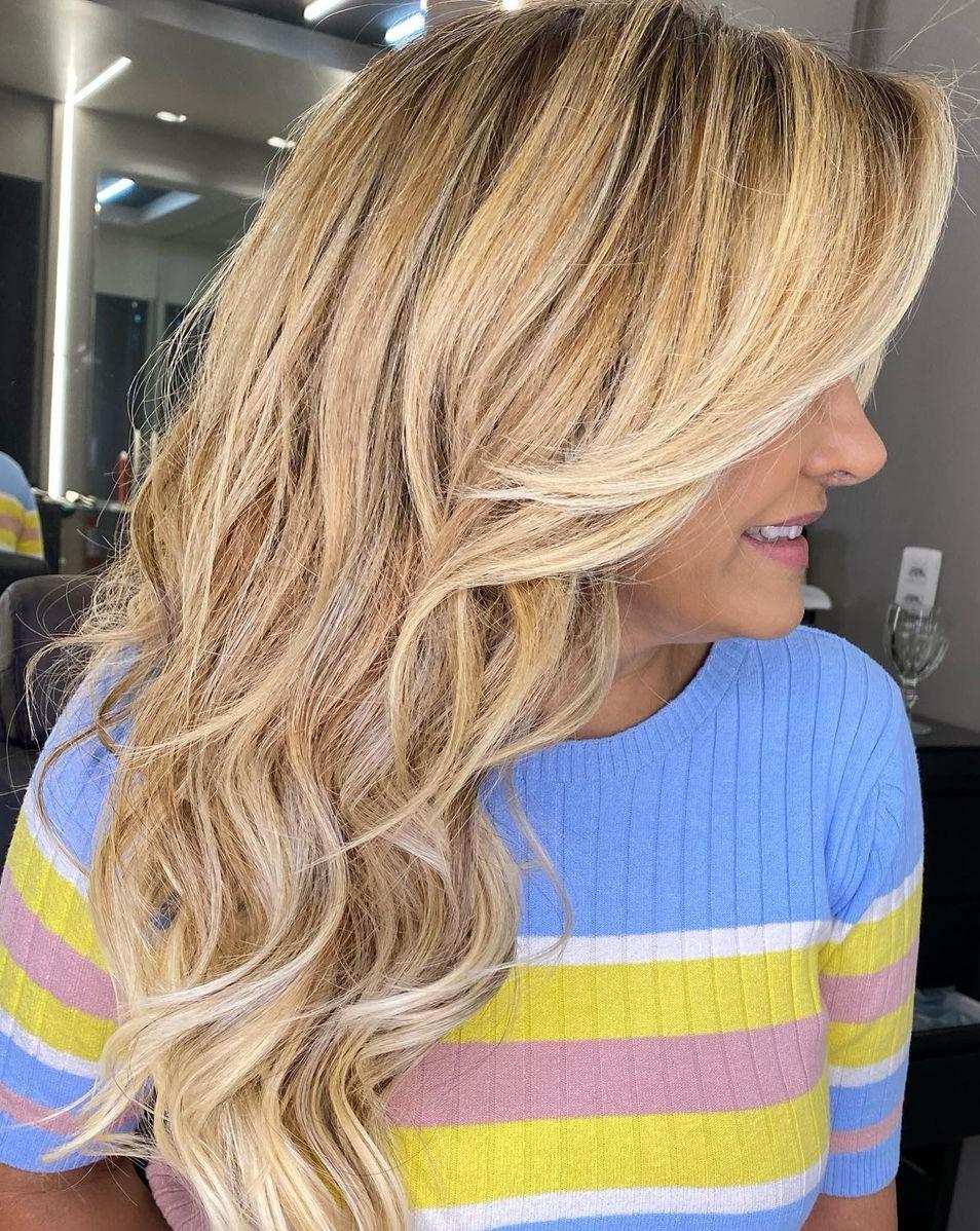 Radiating elegance with this stunning long layered golden blonde hairstyle, perfectly complemented by darker roots for a chic, modern touch!" ✨💁‍♀️