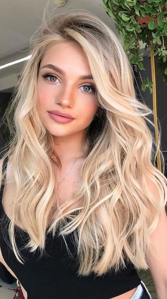 Embrace the radiant glow of this stunning blonde hairstyle, where soft waves meet sun-kissed highlights for a look that